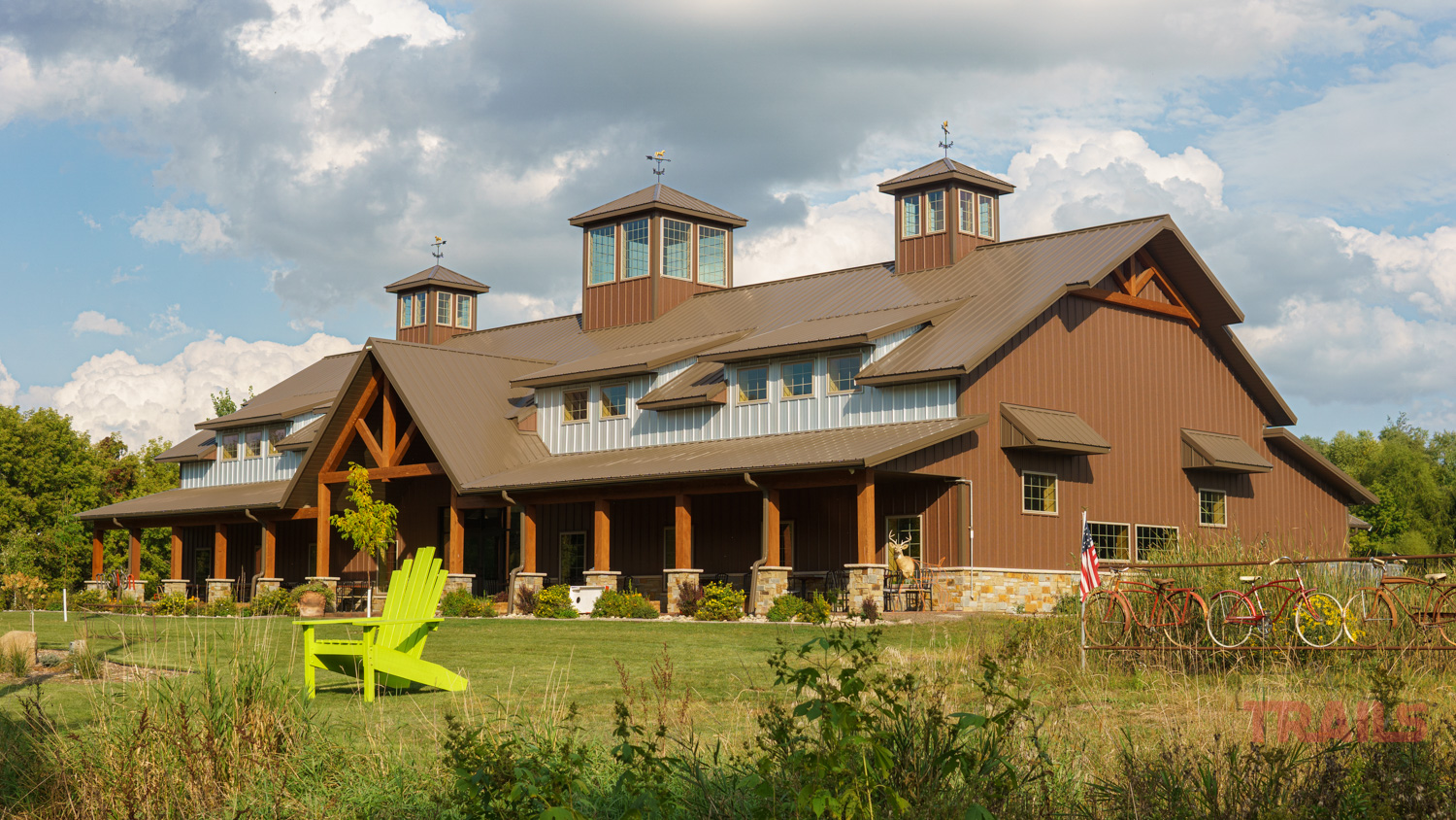 Lake Wobegon Trail-Art in Motion and Boho Cafe A brown metal clad building with timber posts sits on a green lawn