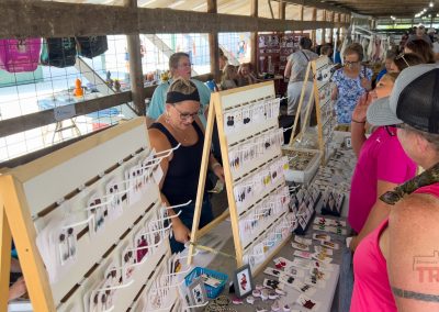 A woman browses outdoor vendors at a fair