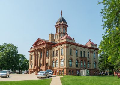 The outside of the Cottonwood County, MN yellow brick courthouse features a cupola and a four column portico