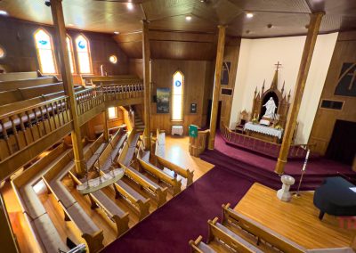 The interior of a historic church is clad entirely with honey-colored wood