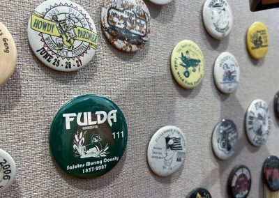 Vintage lapel buttons are displayed on a pin board