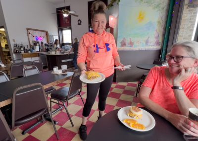 A server in a restaurant brings a plate of food to a patron