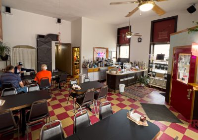 patrons sit at a table in a cafe with red and white checkered floors