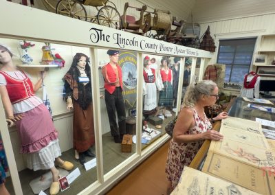A woman studies historical newspapers in a museum
