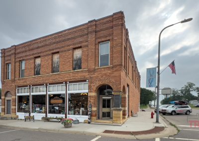 Street view of a two-story, red brick building on a street corner