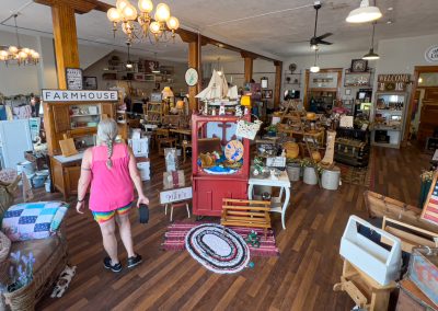 A woman browses a store with antiques and other items