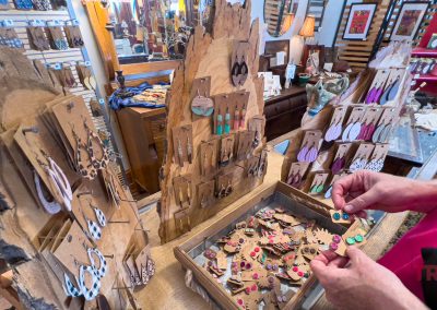 A woman browses a display of earrings in a store