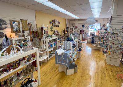 The interior of a gift shop with white walls and wood floors