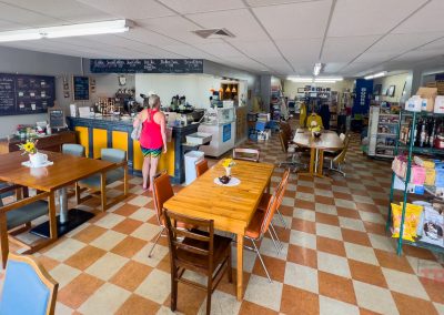 A woman stands by the counter of a coffee shop with red and white checker floors