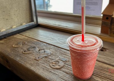 A red smoothie sits on a brown window ledge