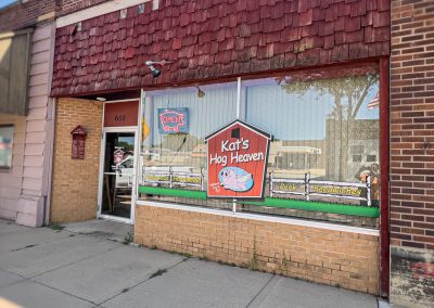 The brown brick and red wood exterior of a BBQ restaurant
