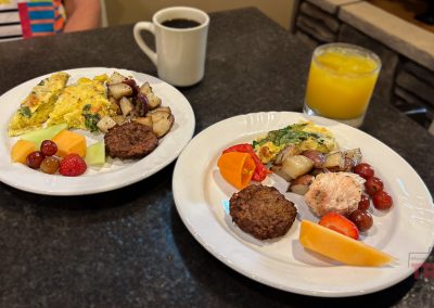 Closeup of two plates of brunch food, coffee and juice