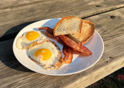 Closeup of a bacon, eggs and toast on a picnic table