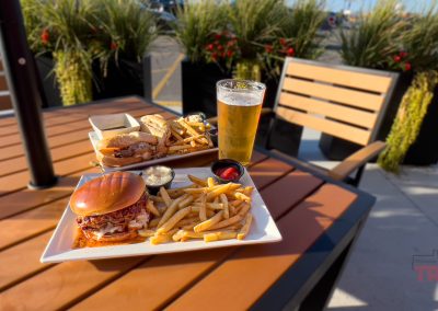A closeup of sandwiches with fries on an outside table