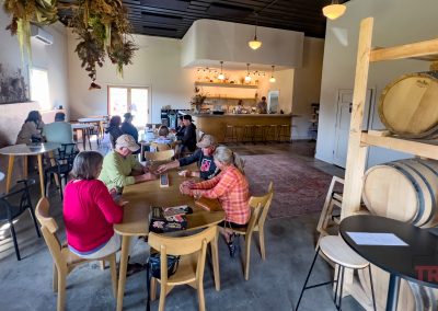 Patrons at a distillery play cribbage in the open tasting room