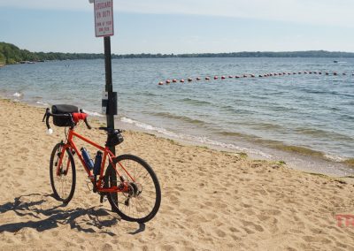 A bicycle leans against a post on a sunny beach