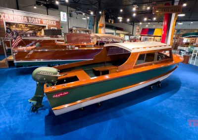 An antique wooden boat on display inside of a museum