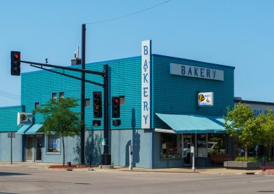 The turquoise lego-like exterior of a bakery on a street corner