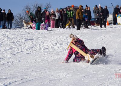 a girl crashes while sledding down a hill on a homemade sled