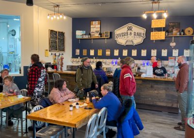 Patrons sit at tables and wait to be served at a brewery tap room