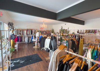The interior of a women's boutique with racks of clothes.