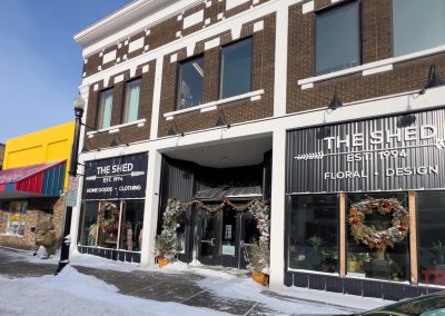 The exterior of a gift shop with shopping windows and brown brick.