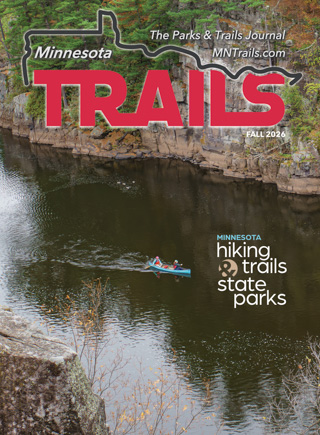 Minnesota Trails Magazine Fall 2026 The cover of the Minnesota Trails Magazine Fall 2026 issue features a canoe with two people paddling on a river between rocky cliffs.